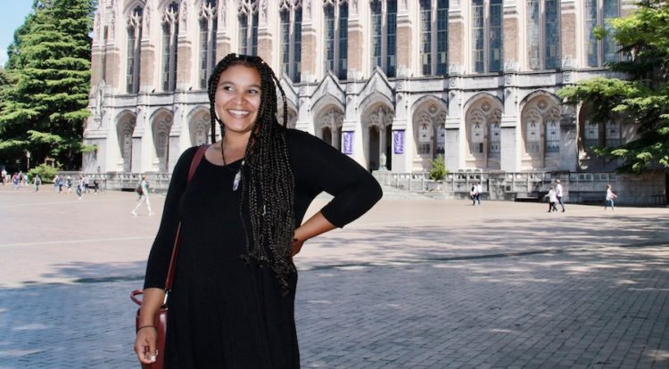 Meshell Sturgis stands in front of Suzzallo Library
