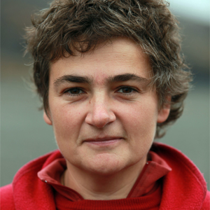 Dr. Fiamma Straneo, a brunette woman with close-cropped hair is wearing a red zip up sweater